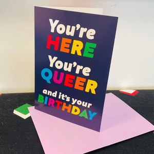 YOU’RE HERE, YOU’RE QUEER Birthday Card